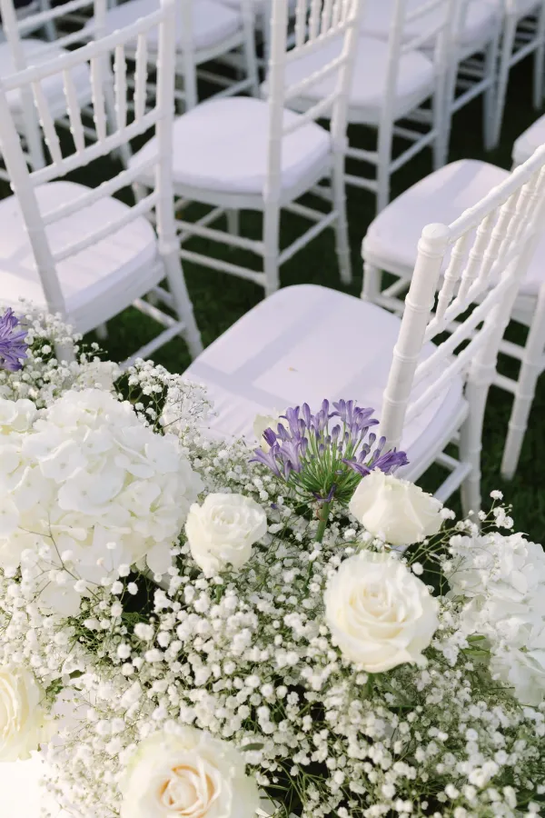 Arreglo floral con rosas blancas, hortensias y agapanto en ceremonia al aire libre